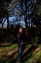 Professor Charlotte Cote standing in a wooded area