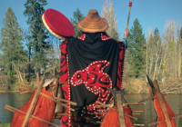 Cover photo of book showing woman wearing traditional Nhu-chah-nulth blanket, with arms raised, holding a drum