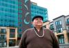 artist Joe Seymour in front of his installed salmon artwork